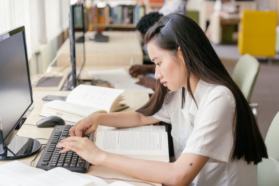 留學生在圖書館使用筆電搜尋獎學金